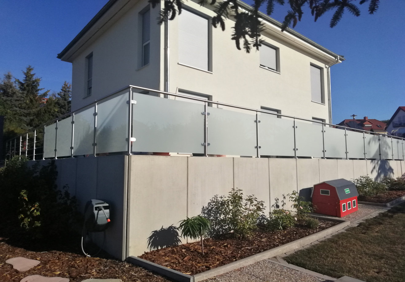 Edelstahl Glasgeländer auf L-Steinen als Grundstücksabgrenzung zum Garten montiert