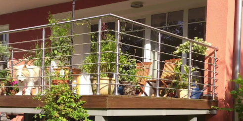 Edelstahl Treppengeländer mit Relingstäben an einem Balkon montiert, Pfosten und Handlauf im Systemaufbau sichtba